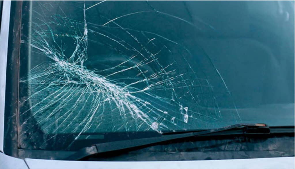 Pare-brise de voiture fissuré avec une large fissure en étoile.